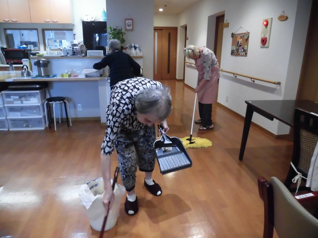 入居者さんが、モップで床を掃除しています